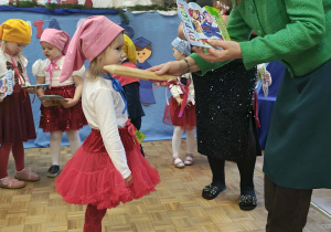 Pani Dyrektor pasuje dziewczynkę ołówkiem na przedszkolaka.