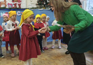 Pani Dyrektor wręcza dziewczynce pamiątkowy dyplom.