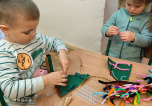 Przedszkolaki ozdabiają choinki.