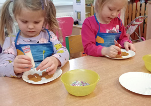 Dziewczynki dekorują pierniczki.