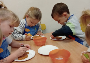 Przedszkolaki ozdabiają pierniki.