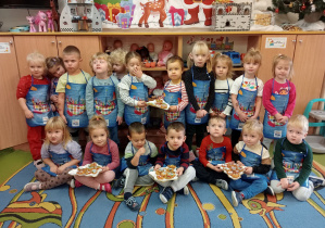 Przedszkolaki trzymają ozdobione pierniki.