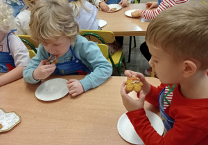 Dzieci jedzą pierniki.