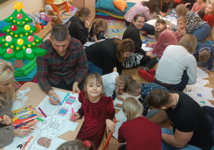 Dzieci i rodzice kolorują obrazki.