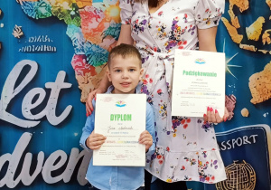 Janek stoi z wychowawcą i trzyma dyplom.