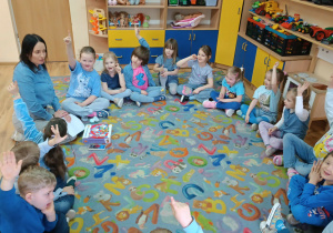 Dzieci siedzą w kole z panią psycholog.