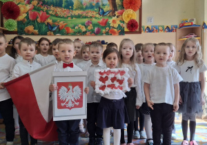 Dzieci z grupy 4-, 5-latków trzymają flagę oraz godło.