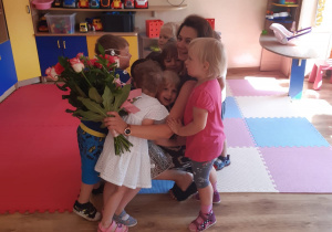 Dzieci wręczają prezent i kwiaty wychowawczyni.