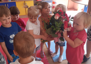 Dzieci trzymają kwiaty.
