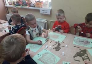 Dzieci wykonują jeżyka z pasków papieru.