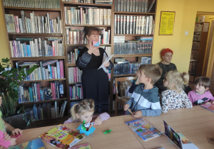 Dzieci słuchają objaśnień bibliotekarki .
