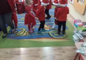 Dzieci tańczą taniec dla Mikołaja.