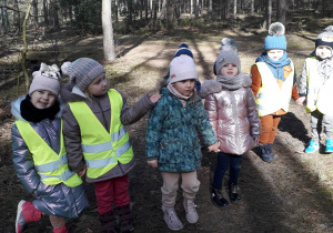 Dzieci na spacerze w lesie.