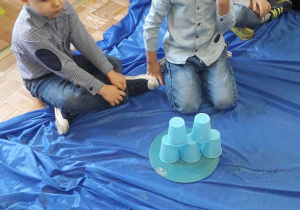 Dzieci układają wieżę z kubeczków