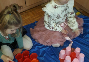 Dzieci układają kwiaty z kubeczków