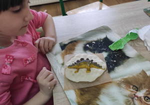 Dzieci wykonują odciski z dinozaurów.