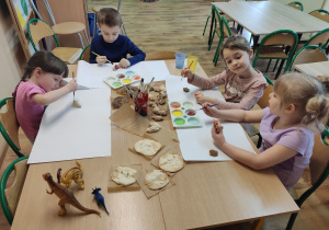 Dzieci malują dinozaury.