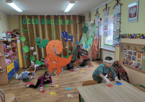 Dzieci chodzą po śladach dinozaurów.
