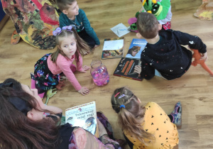 Dzieci oglądają książki o dinozaurach.