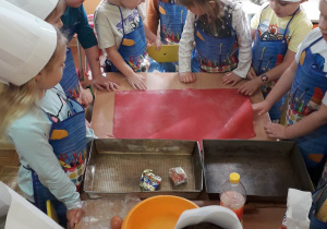 Dzieci przygotowują się wyrabiania ciasta.