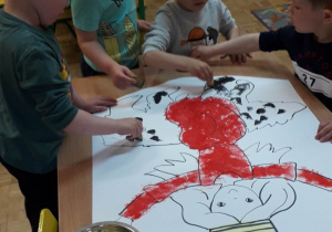 Dzieci malują stempelkami herb miasta.