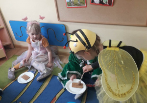 Pszczółka Basia daje dzieciom miodek.