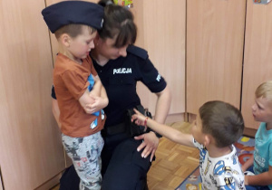 Pani policjantka rozmawia z dziećmi o bezpieczeństwie w czasie wakacji.