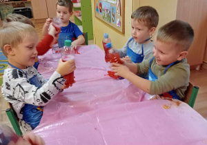Dzieci potrząsają butelkę z zabarwioną wodą