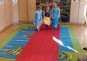 Dziewczynki prezentują swoje stroje na czerwonym dywanie