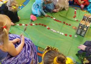 Grupa 3-latków układa dróżkę z płatków róży do zamku Królewny Śnieżki