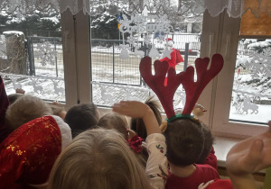 Dzieci witają w oknie Mikołaja