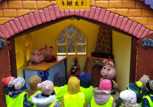 Dzieci oglądają domek z bajki "Trzy Małe Świnki"