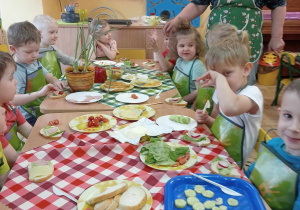 Dzieci z panią Beatką przygotowują kanapki