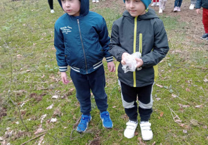 Dzieci szukają w lesie śmieci