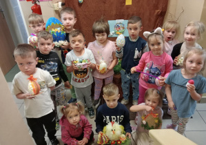 Uczestnicy konkursu stoją ze swoimi pracami.