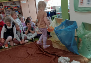 Dziewczynka segreguje plastik do odpowiedniego worka.