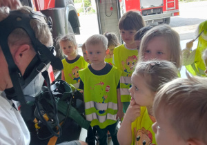 Dzieci słuchają ciekawostek na temat pracy strażaków.