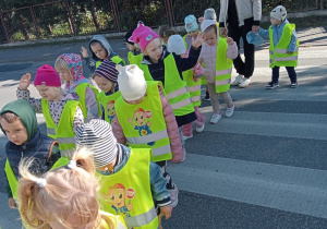 Przedszkolaki przechodzą przez przejście dla pieszych.