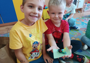 Chłopcy pokazują ślimaka, którego zrobili.
