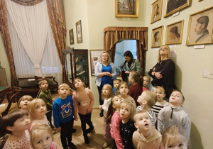 Dzieci oglądają eksponaty w jednej z sal muzealnych.