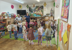 Przedszkolaki tańczą w kole.