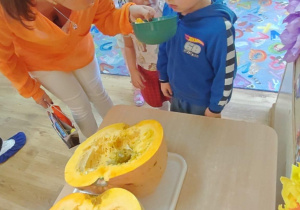 Dzieci oglądają wnętrze dyni.