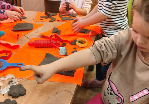 Przedszkolaki lepią z gliny.