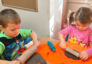 Dzieci rozwałkowują glinę.