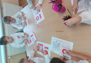 Chłopcy kolorują godło i flagę Polski.