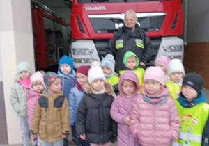 Dzieci stoją przed budynkiem OSP.