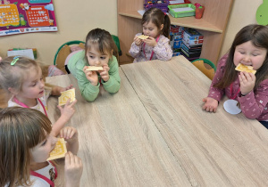 Dziewczynki jedzą wafle z miodem.