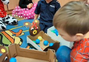 Dzieci bawią się kolorowymi kulkami.