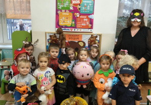 Przebrane przedszkolaki stoją ze swoimi misiami.